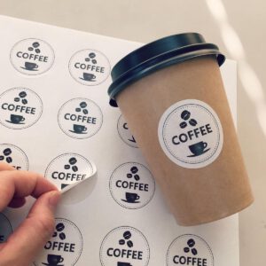 round die cut sticker being peeled off the sheet and pasted on cup